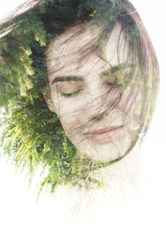 Creative double exposure portrait of woman combined with photograph of nature